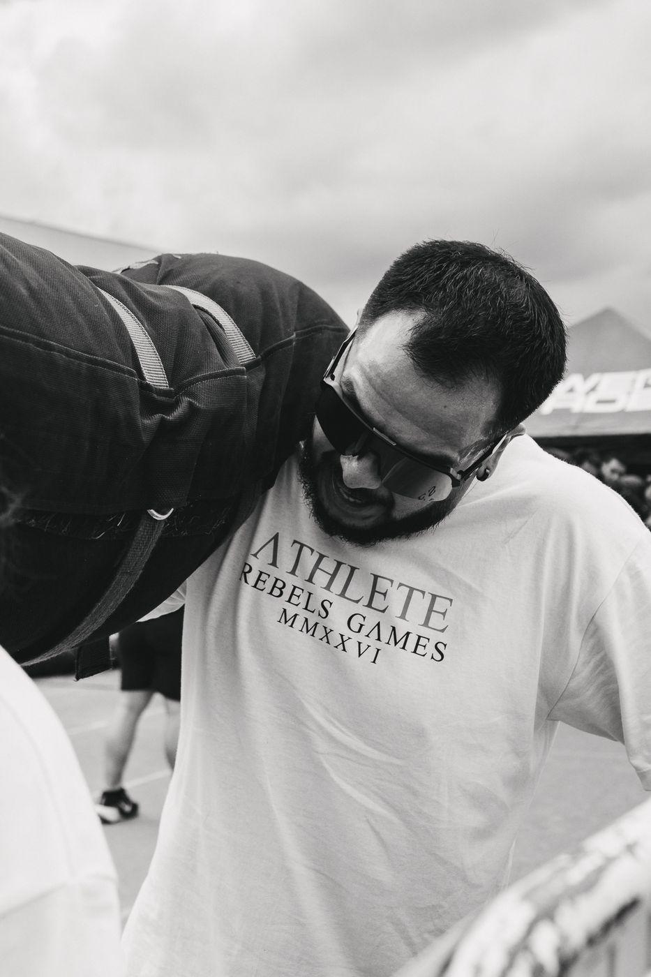 Atleta cargando a su compañero en la espalda, en blanco y negro