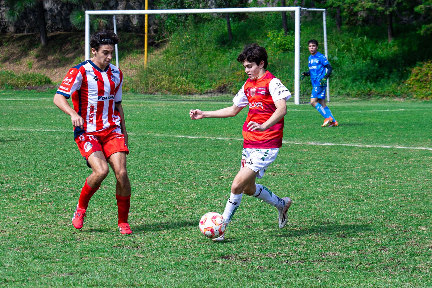 Dos jugadores disputando el balón en el área