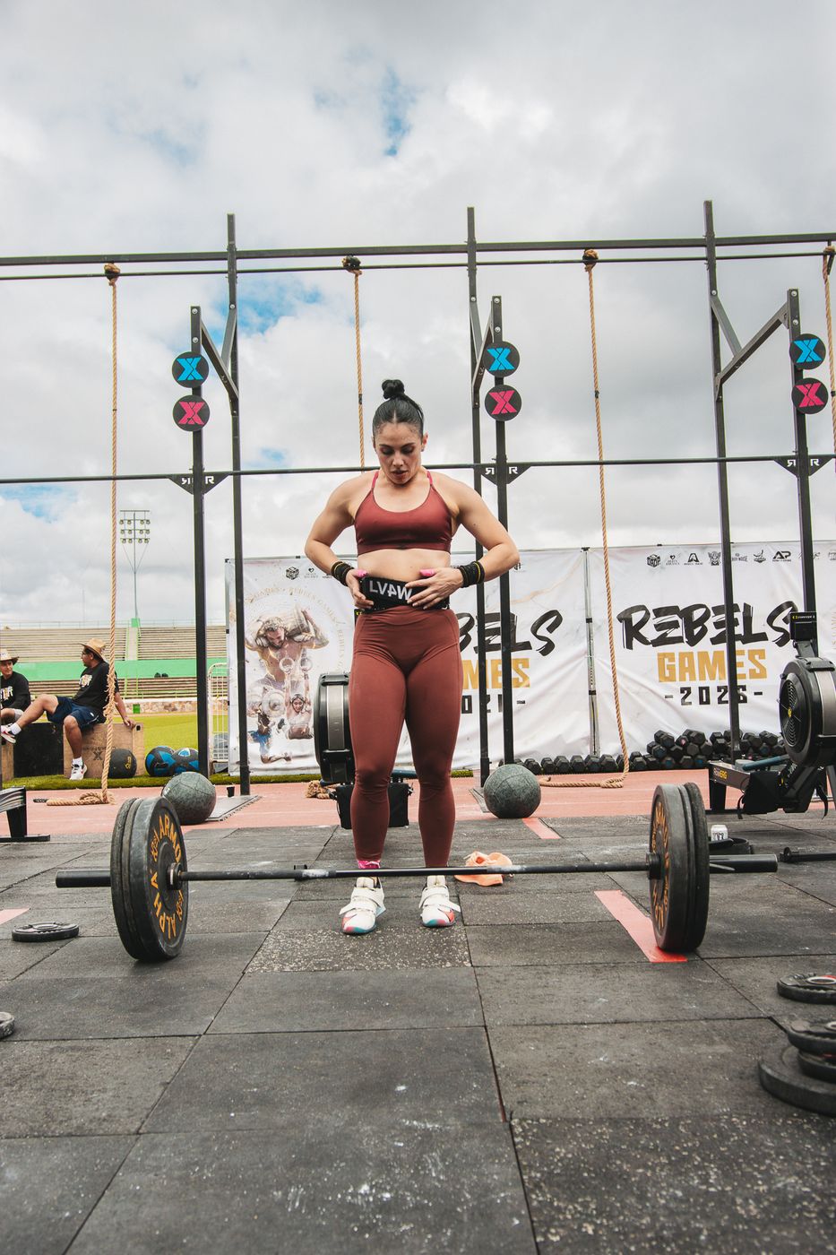 Atleta de pie frente a su barra entre los rigs de competencia