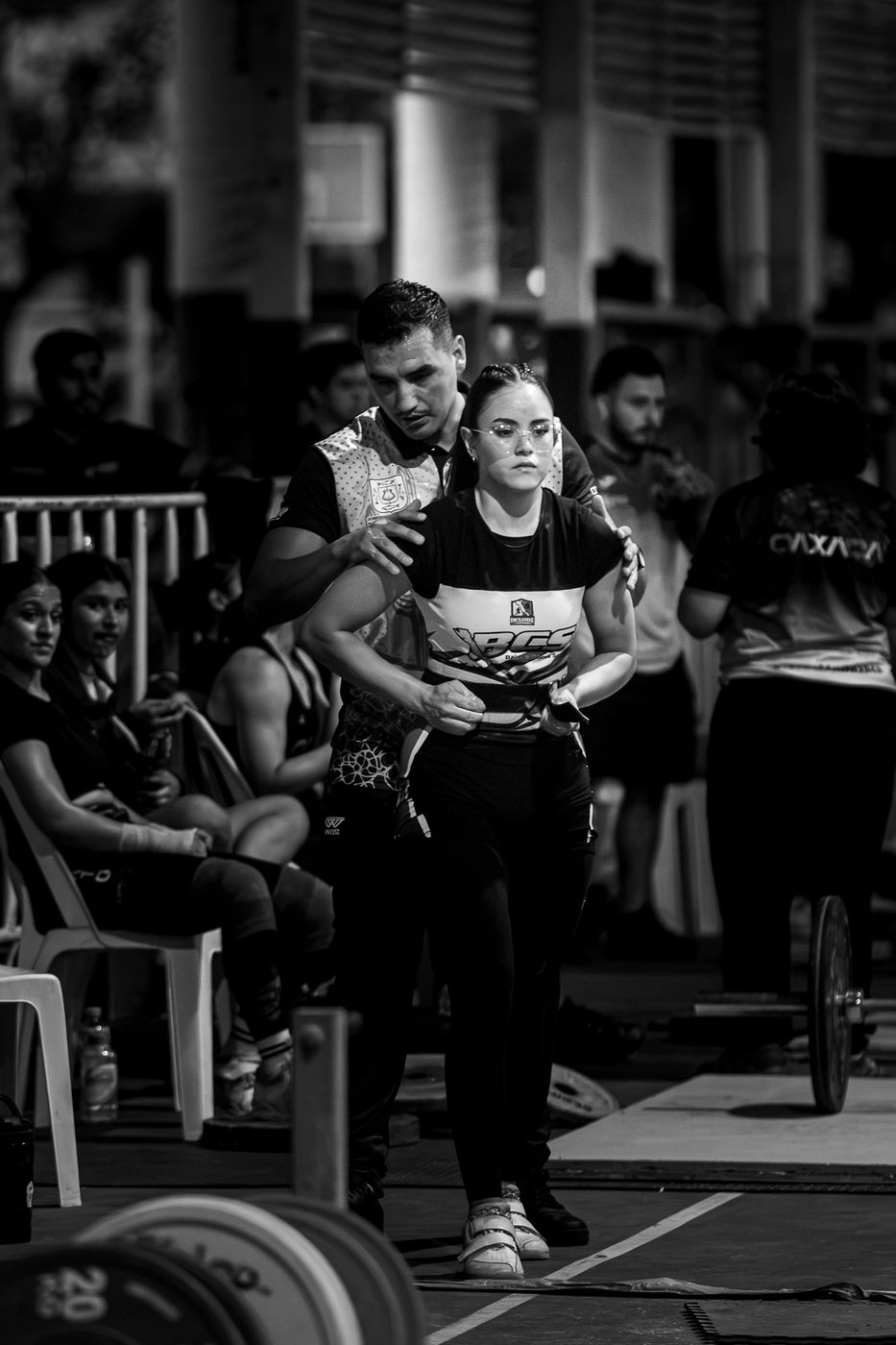 Atleta en el área de calentamiento entre el público, en blanco y negro