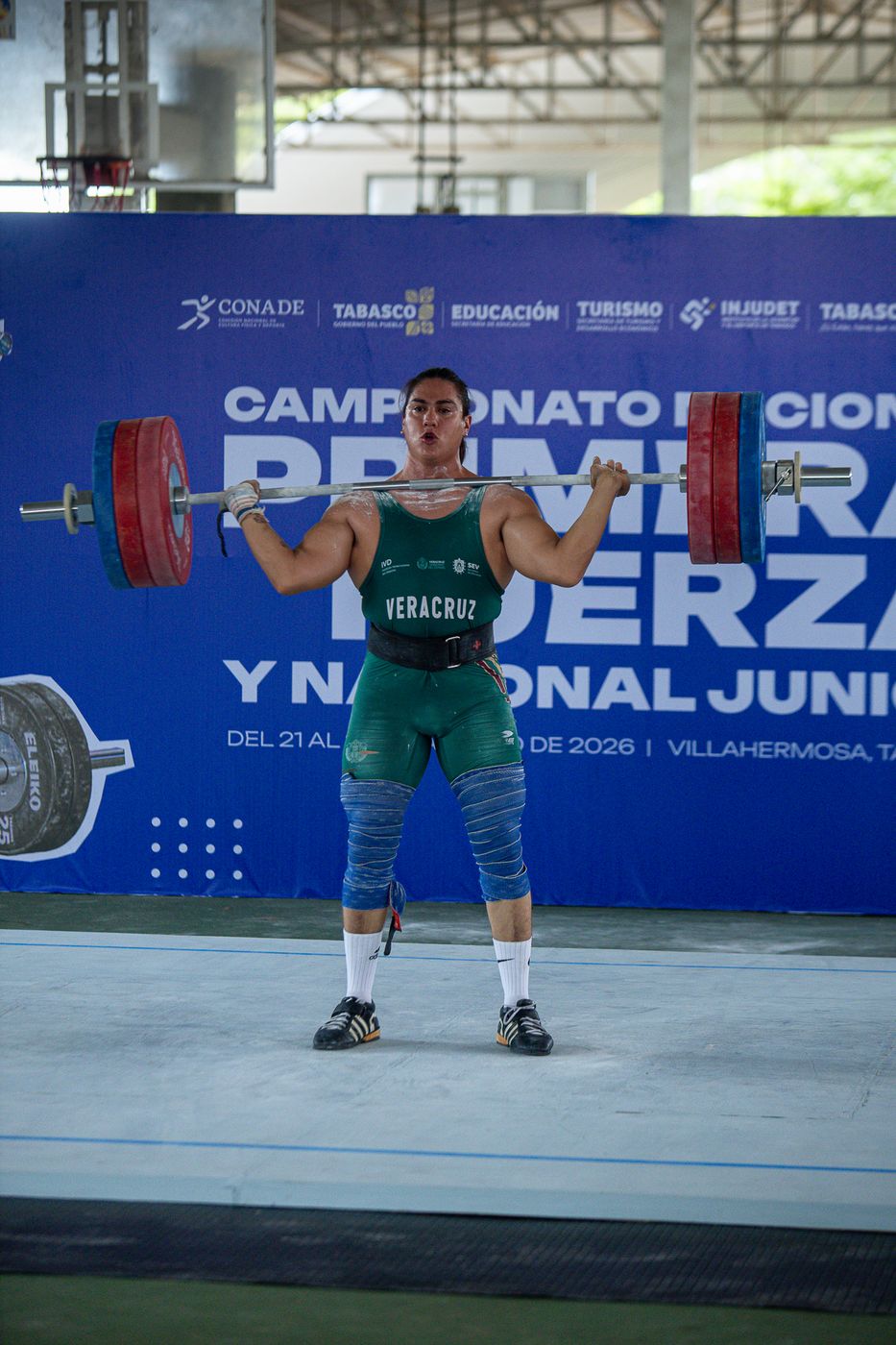 Atleta sosteniendo la barra sobre la cabeza en el Campeonato Nacional