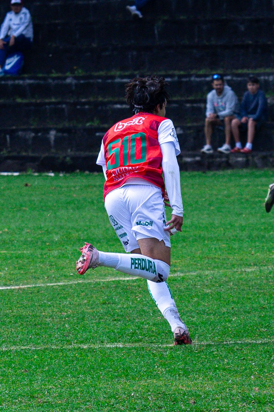 Jugador con el número 10 a mitad de zancada en la cancha