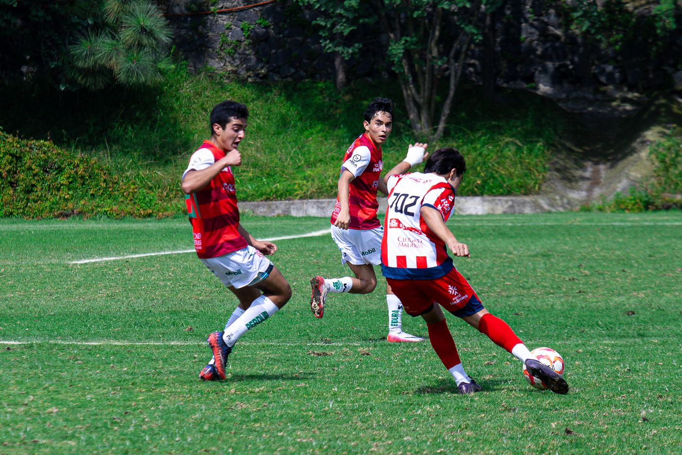 Jugador pateando el balón ante la marca de un rival