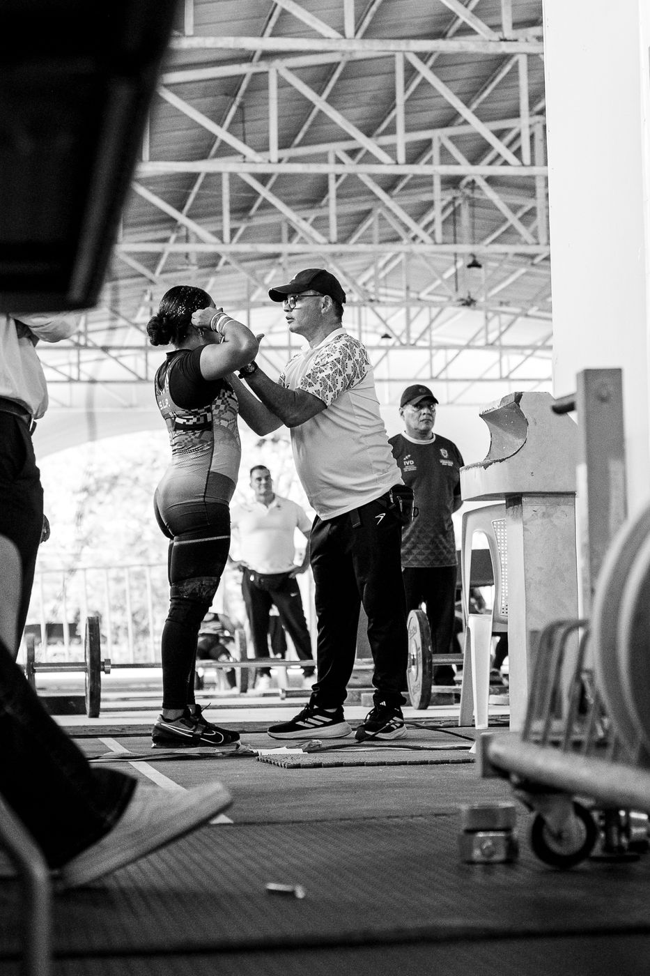Entrenador dando indicaciones a su atleta junto a la plataforma, en blanco y negro
