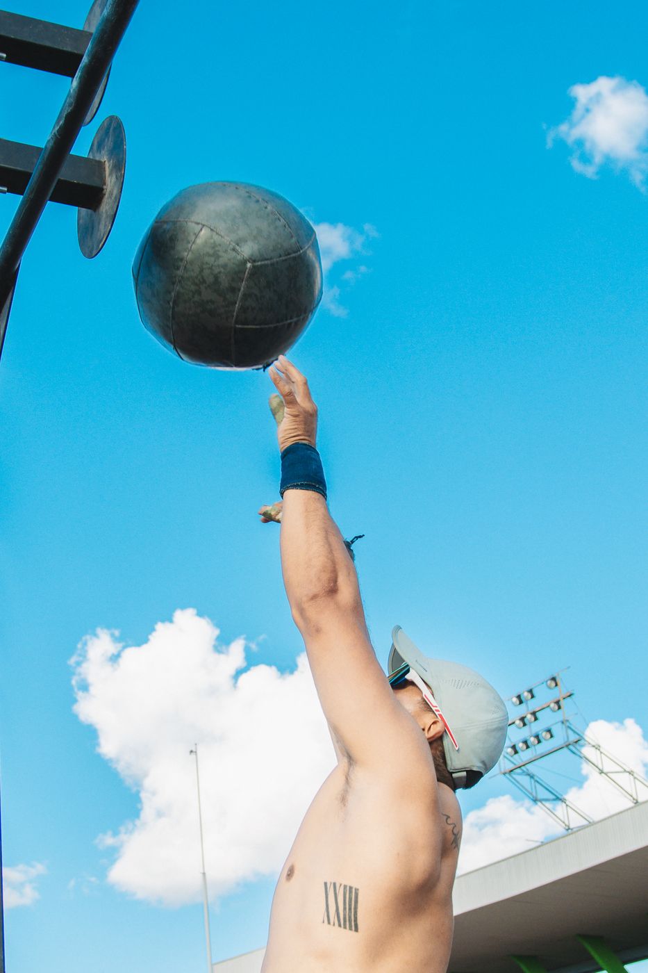 Atleta lanzando un balón medicinal hacia el cielo